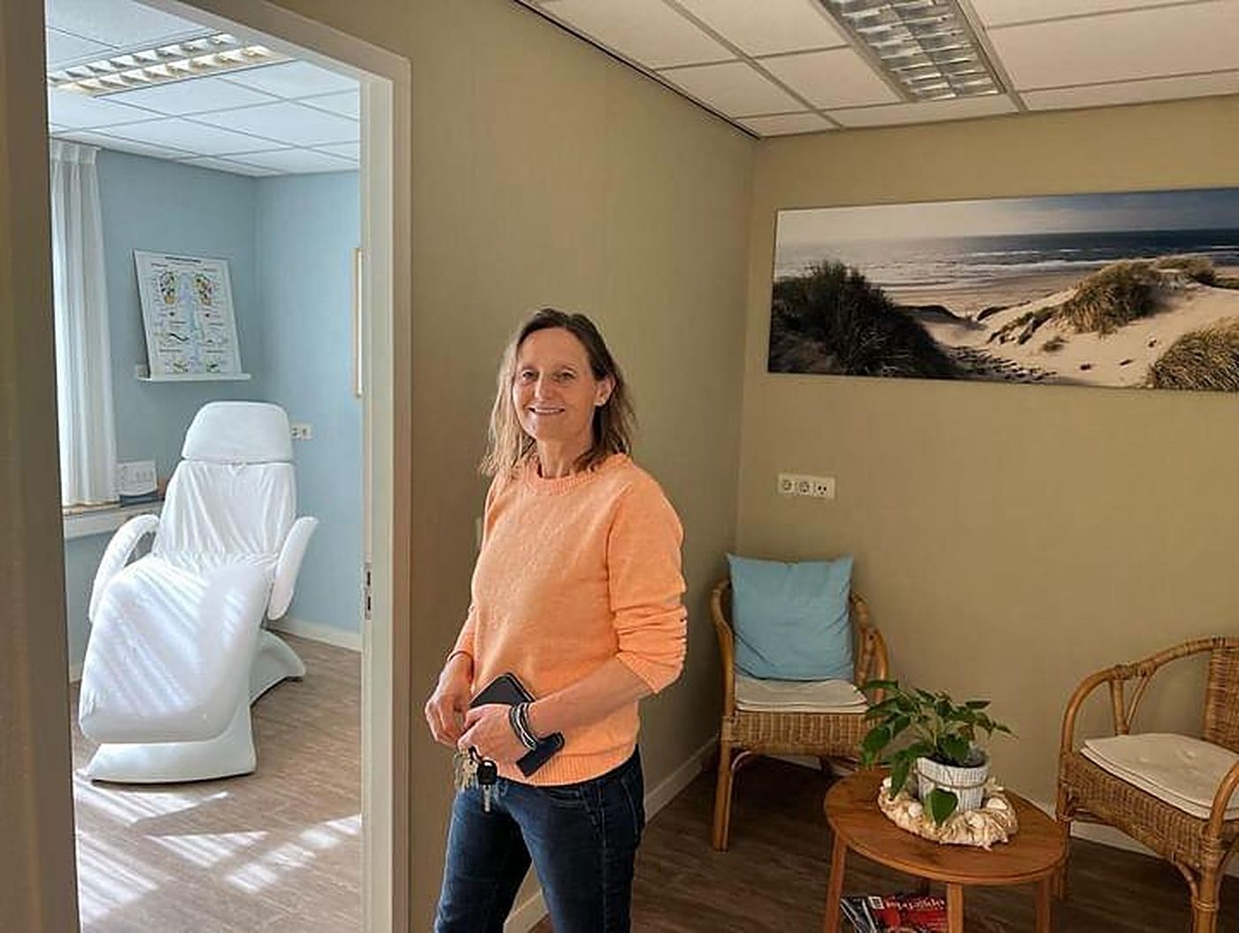 Ellen in de wachtruimte van haar praktijk, met de behandelkamer op de achtergrond